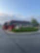 Red building with black roof and landscaping
